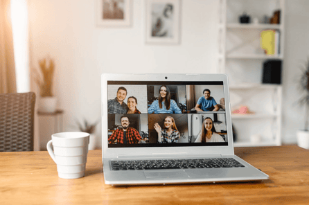 laptop screen shows virtual meeting